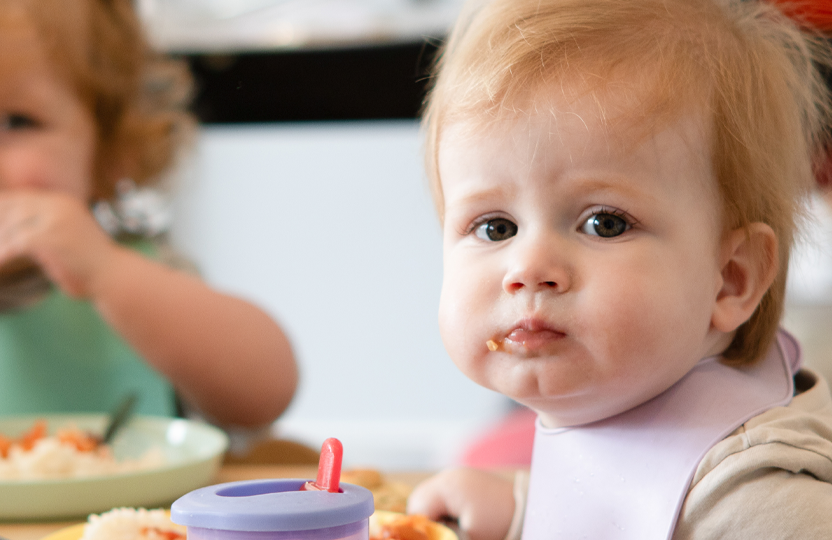 Baby wearing a bib and sitting in a highchair at mealtime