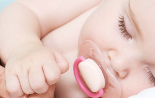 Baby sleeping peacefully with a dummy in their mouth
