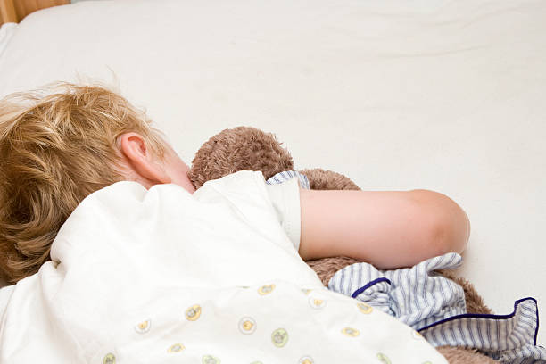 Sleeping child cuddling a soft toy